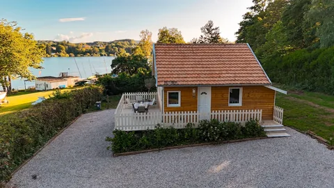 Le chalet, son allée de gravier et le bassin au fond