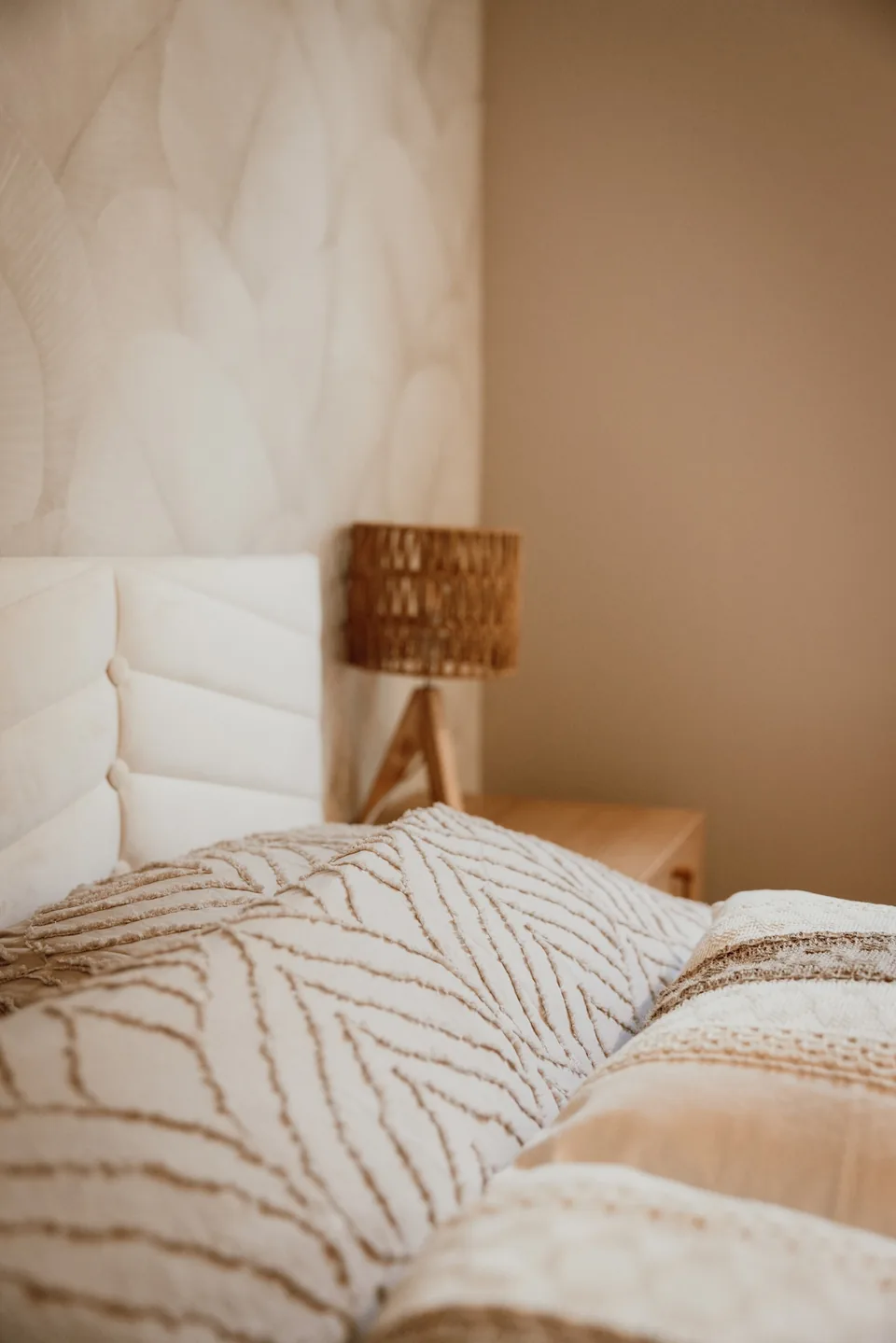 Le lit et sa tête de lit capitonnée, dans la chambre du chalet