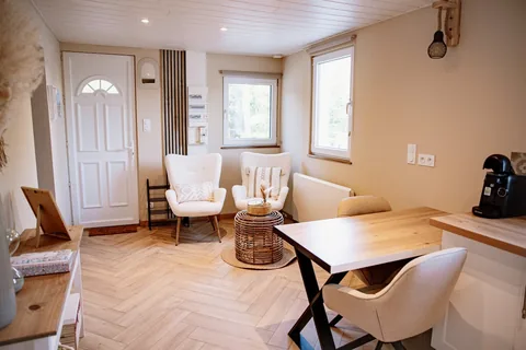Le séjour au parquet en chevrons, ouvert sur la cuisine