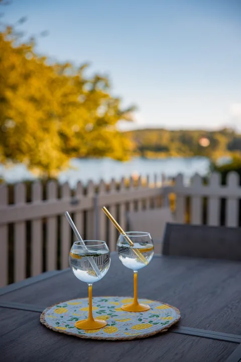 Deux verres sur la table de la terrasse, le bassin au loin