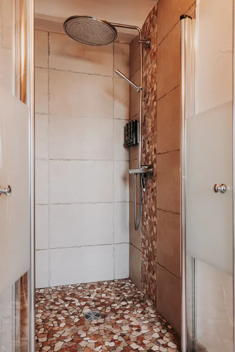 Die Dusche im Bad mit Steinmosaik