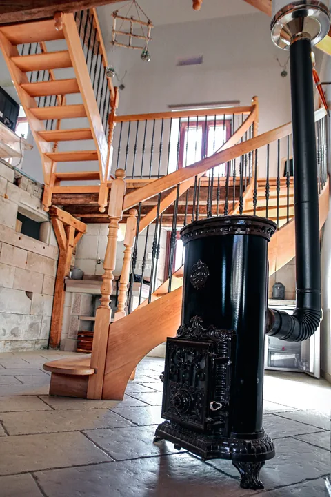 Der gusseiserne Holzofen am Fuß der Treppe
