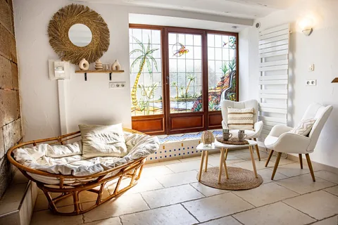 Die Veranda mit Rattansesseln, offen zum Garten